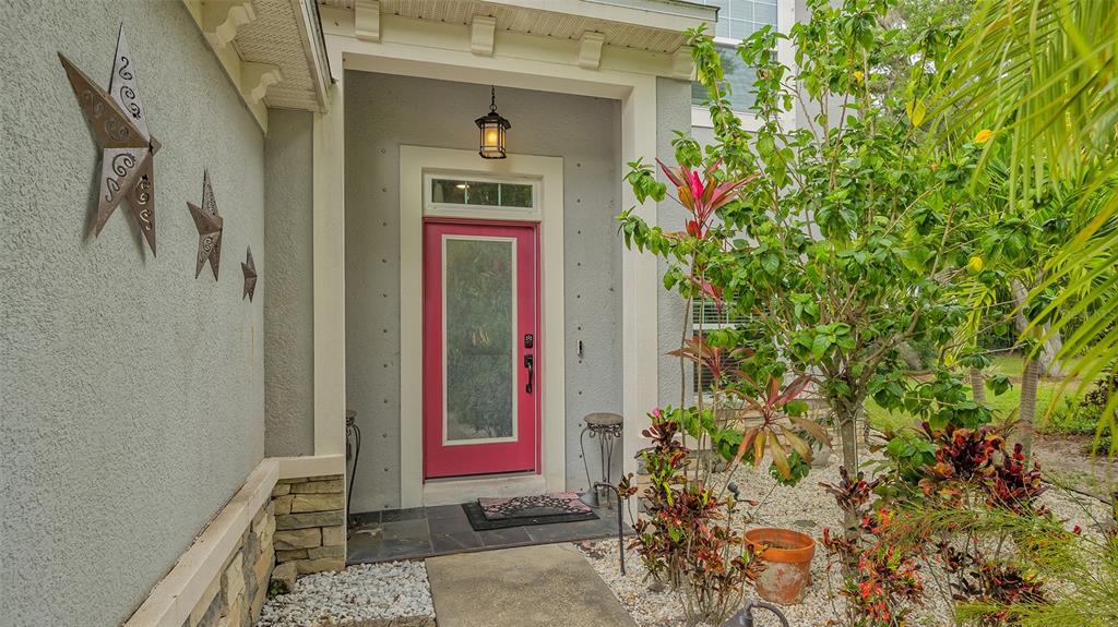 A front entrance features a bright pink door, stone accents, and decorative metal stars — 86 ARBOR OAKS DRIVE, SARASOTA, FL