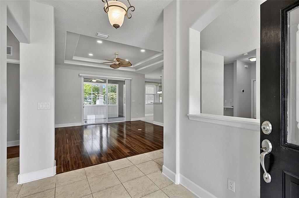 An entryway with tile flooring leads into a living area featuring dark wood floors — 66 RAMBLEWOOD DRIVE, PALM COAST, FL