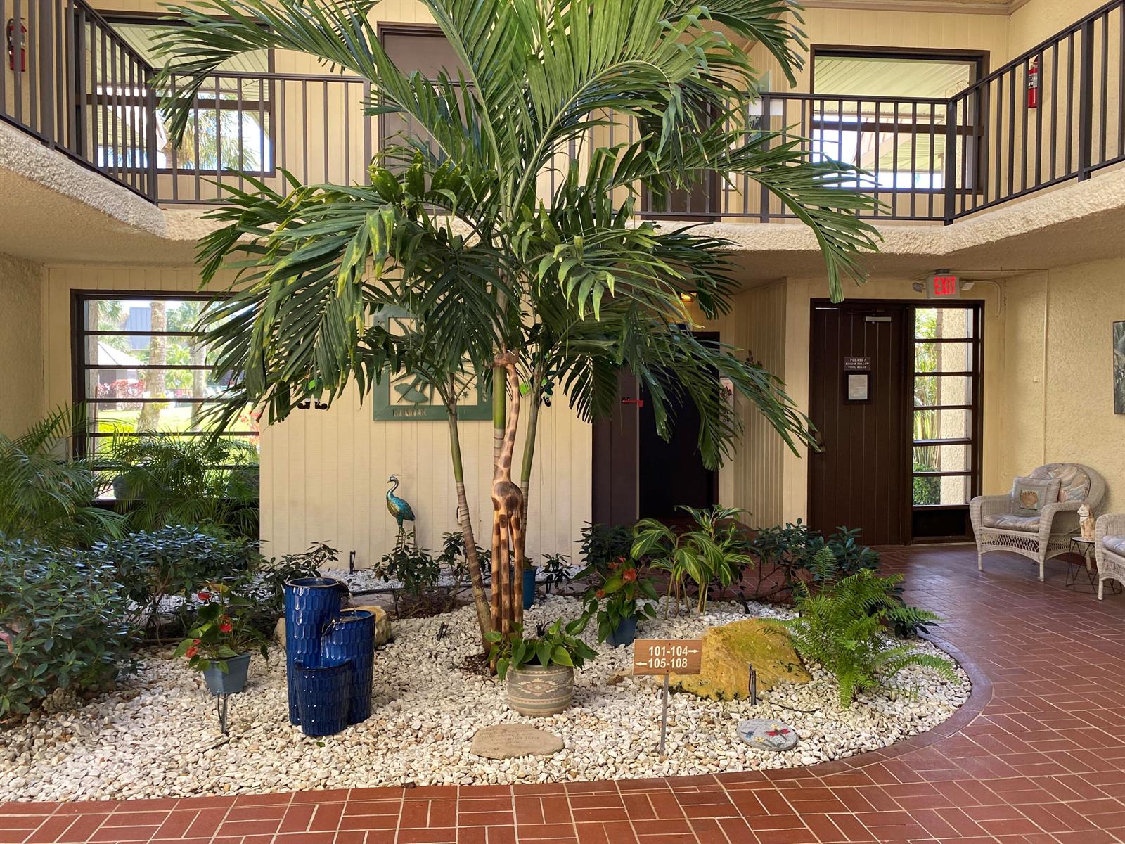 An open-air courtyard features a central palm tree, a blue fountain, and tiled walkways — 1800 SE Saint Lucie Boulevard # 203, Stuart FL 34996, STUART, FL