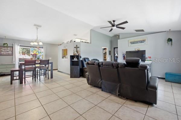 A living room and dining area with tile flooring, a ceiling fan, and leather furniture — 13185 SW 2ND COURT, OCALA, FL