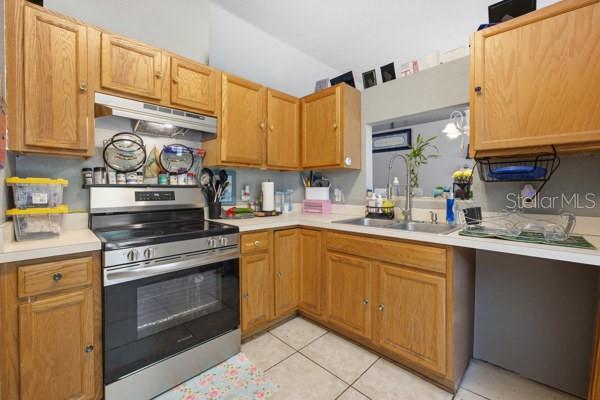 A kitchen features light wood cabinets, a stainless steel stove, and a double-basin sink — 13185 SW 2ND COURT, OCALA, FL