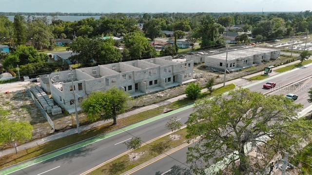 An aerial view shows two multi-unit residential buildings under construction along a paved road — 2042 ORANGE CENTER BOULEVARD, ORLANDO, FL