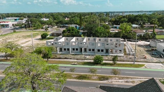 An aerial view shows a multi-unit residential building under construction with exposed concrete block walls — 2042 ORANGE CENTER BOULEVARD, ORLANDO, FL
