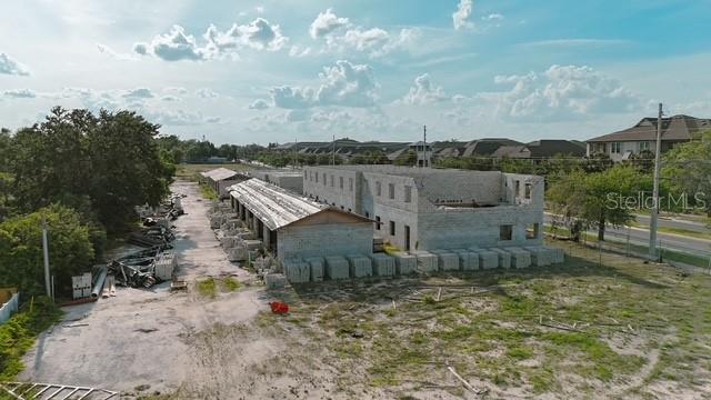 An aerial view shows a multi-story building under construction with concrete block walls and scaffolding — 2042 ORANGE CENTER BOULEVARD, ORLANDO, FL