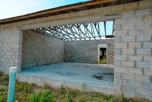 An unfinished concrete block structure shows an open garage space with exposed roof trusses — 2042 ORANGE CENTER BOULEVARD, ORLANDO, FL