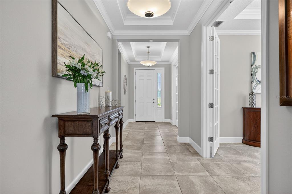 A bright foyer features tile flooring, a wooden console table, and a white front door — 5238 MOREY FARMS LOOP, PALMETTO, FL