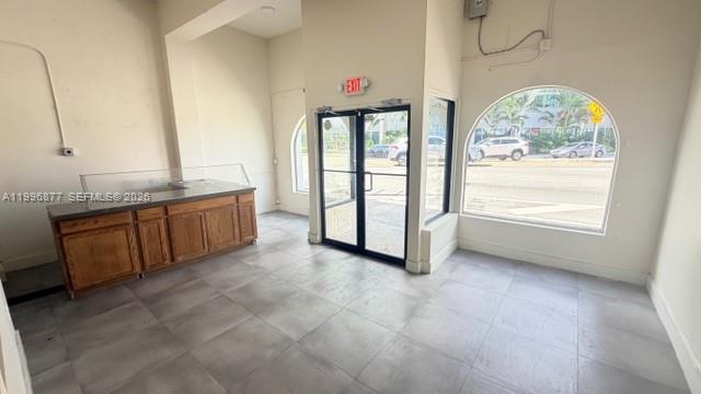 An empty commercial space with gray tile flooring, a wooden counter, and large arched windows — 2606 SW 8th St, Miami FL 33135, MIAMI, FL