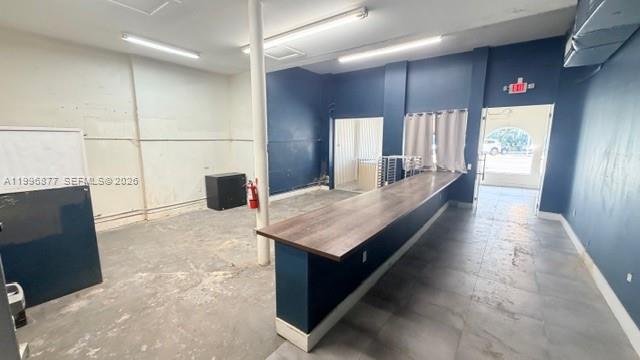 An empty commercial space features a long wooden counter, blue walls, and tile flooring — 2606 SW 8th St, Miami FL 33135, MIAMI, FL