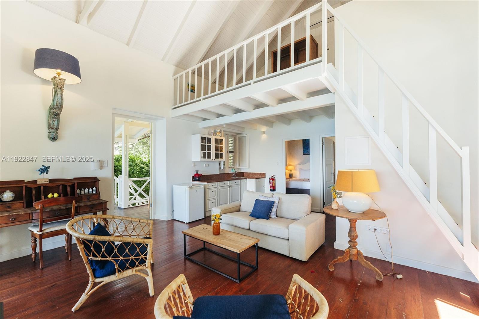 A living room with a kitchenette, loft area, wooden floors, and stairs to an upper level — 0000 N Penstraat, 0000, FL