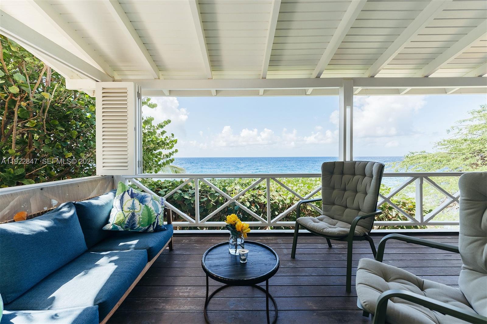 A covered wooden deck features outdoor seating and a direct view of the ocean — 0000 N Penstraat, 0000, FL