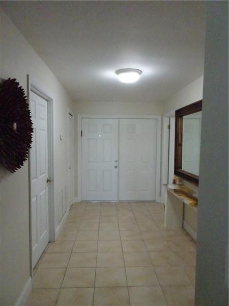 A tiled entryway features a double front door, a wall mirror, and a ceiling light — 96 Del Rio Boulevard, Boca Raton FL 33432, BOCA RATON, FL