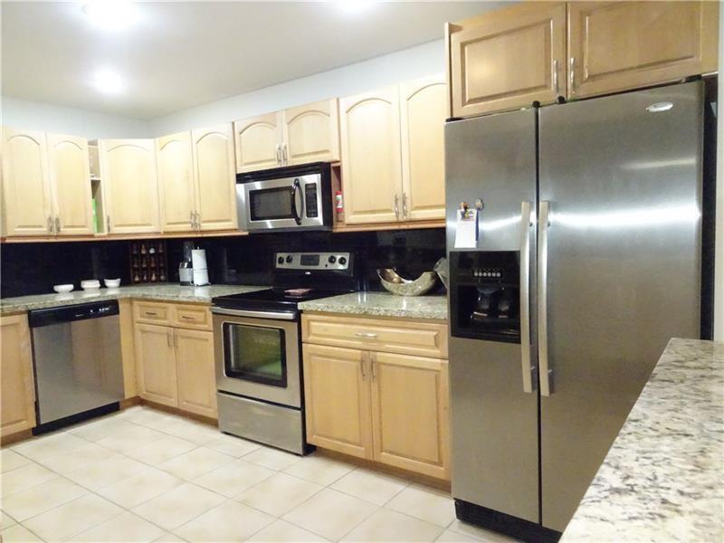 A kitchen features light wood cabinets, stainless steel appliances, and granite countertops — 96 Del Rio Boulevard, Boca Raton FL 33432, BOCA RATON, FL