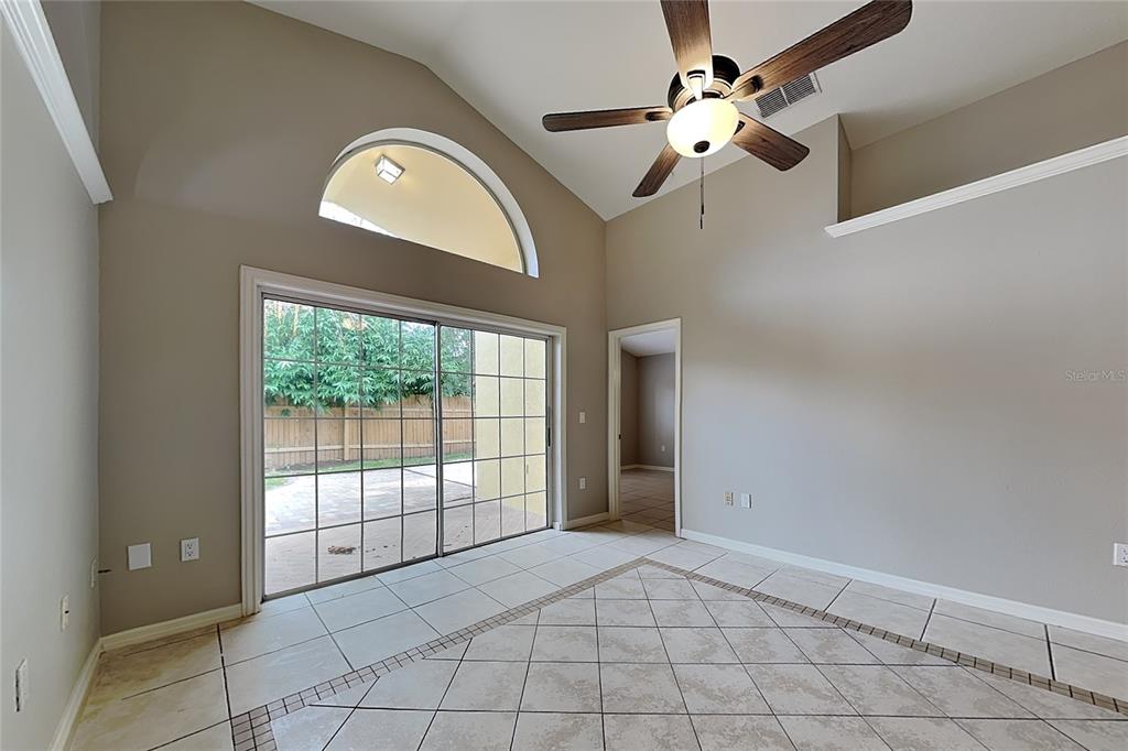 A room with vaulted ceilings, tile flooring, a ceiling fan, and sliding glass patio doors — 2517 CLARESIDE DRIVE, VALRICO, FL