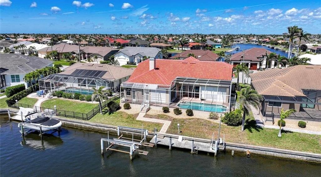 An aerial view of a waterfront house with a red tile roof and swimming pool — 341 SEGOVIA DRIVE, PUNTA GORDA, FL