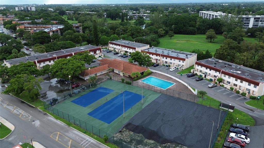 An aerial view shows apartment buildings, a swimming pool, and tennis courts — 4152 Inverrary Drive # 202, Lauderhill FL 33319, LAUDERHILL, FL