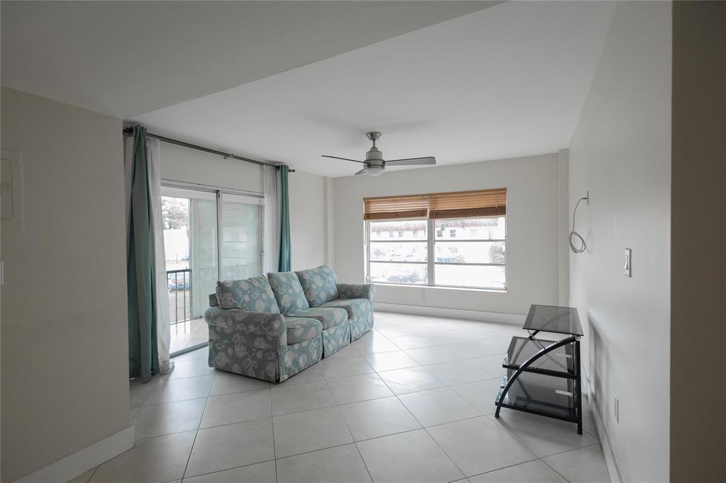 A living room features light tile floors, a floral sofa, and a glass TV stand — 4152 Inverrary Drive # 202, Lauderhill FL 33319, LAUDERHILL, FL