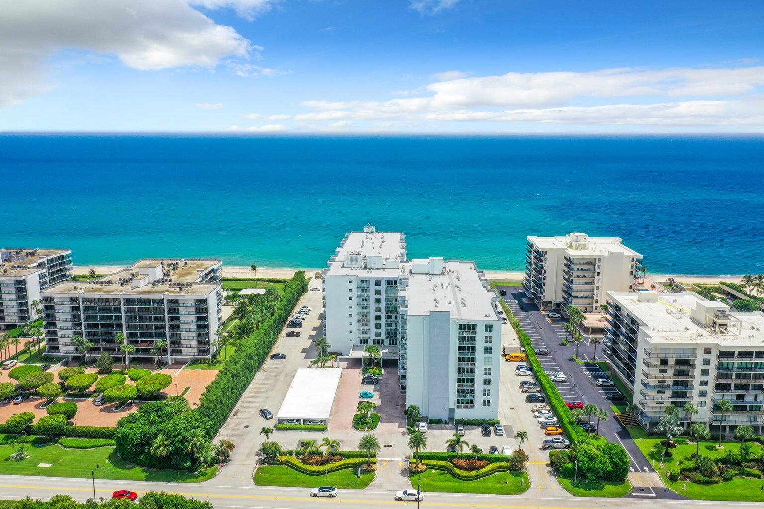An aerial view of several white apartment buildings situated along a sandy beach and ocean — 3450 S Ocean Boulevard # 621, Palm Beach FL 33480, PALM BEACH, FL