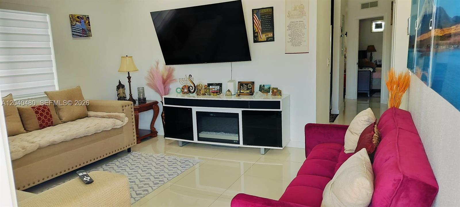 A living room features a large television, a fireplace console, and two sofas — 4223 NW 32nd Ave, Miami FL 33142, MIAMI, FL
