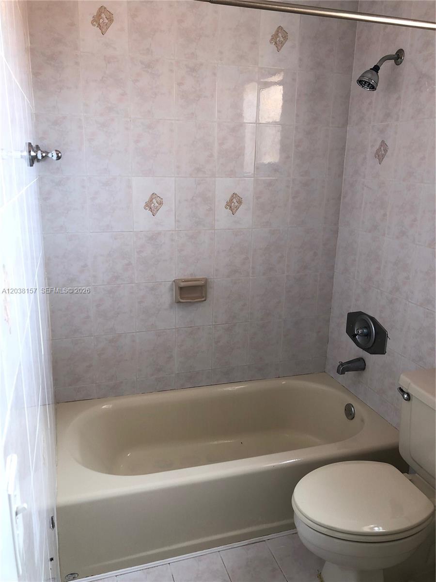 A bathroom features a beige bathtub, a shower head, and a white toilet — 3808 SW 79th Ave # 63, Miami FL 33155, MIAMI, FL