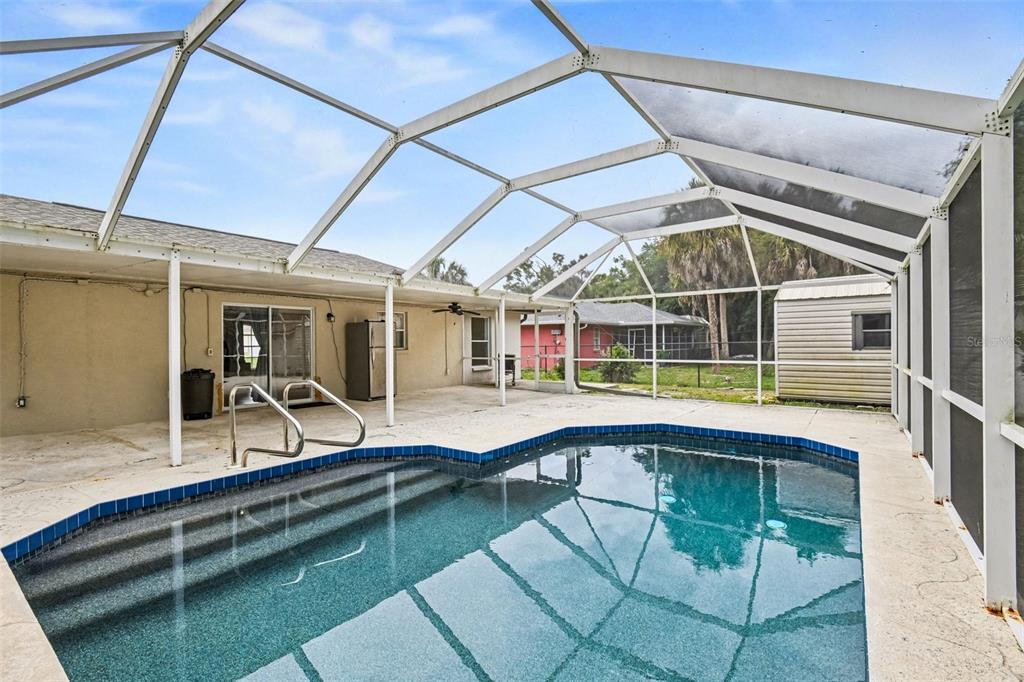 A screened-in patio features a swimming pool with steps and a concrete deck — 2638 ASHLAND LANE, NORTH PORT, FL
