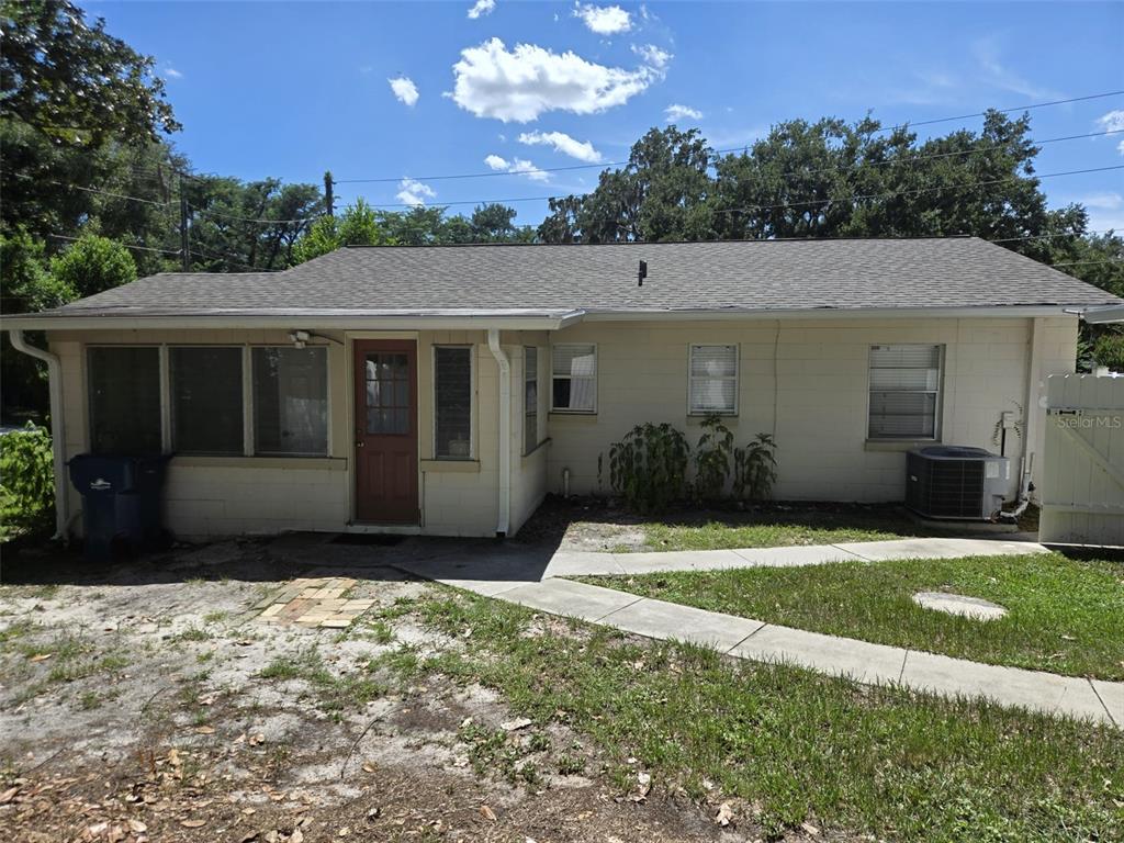 A single-story house with a light-colored exterior, a red front door, and a concrete walkway — 659 N KEPLER ROAD, DELAND, FL