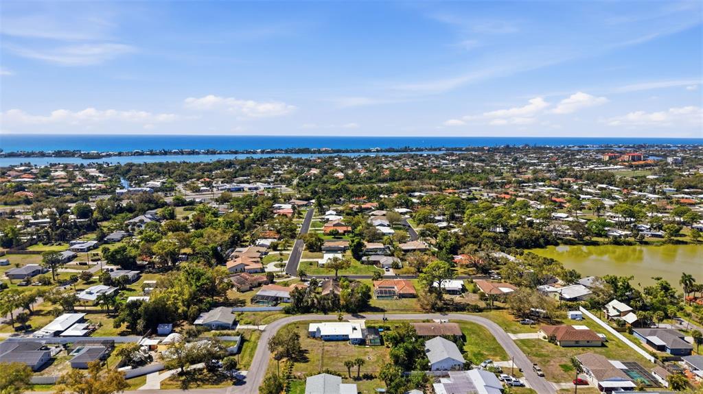 An aerial view shows a residential neighborhood with houses, trees, and a nearby lake — PALMETTO STREET, NOKOMIS, FL