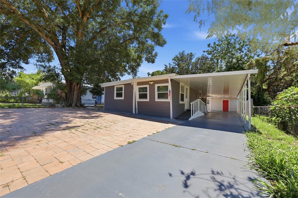 A gray house with a paved driveway, a carport, and a large tree in the yard — 188 MOBILE AVENUE, ALTAMONTE SPRINGS, FL