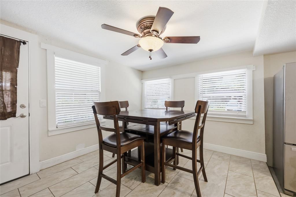 A dining area features a square wooden table with four chairs, tile flooring, and windows — 188 MOBILE AVENUE, ALTAMONTE SPRINGS, FL