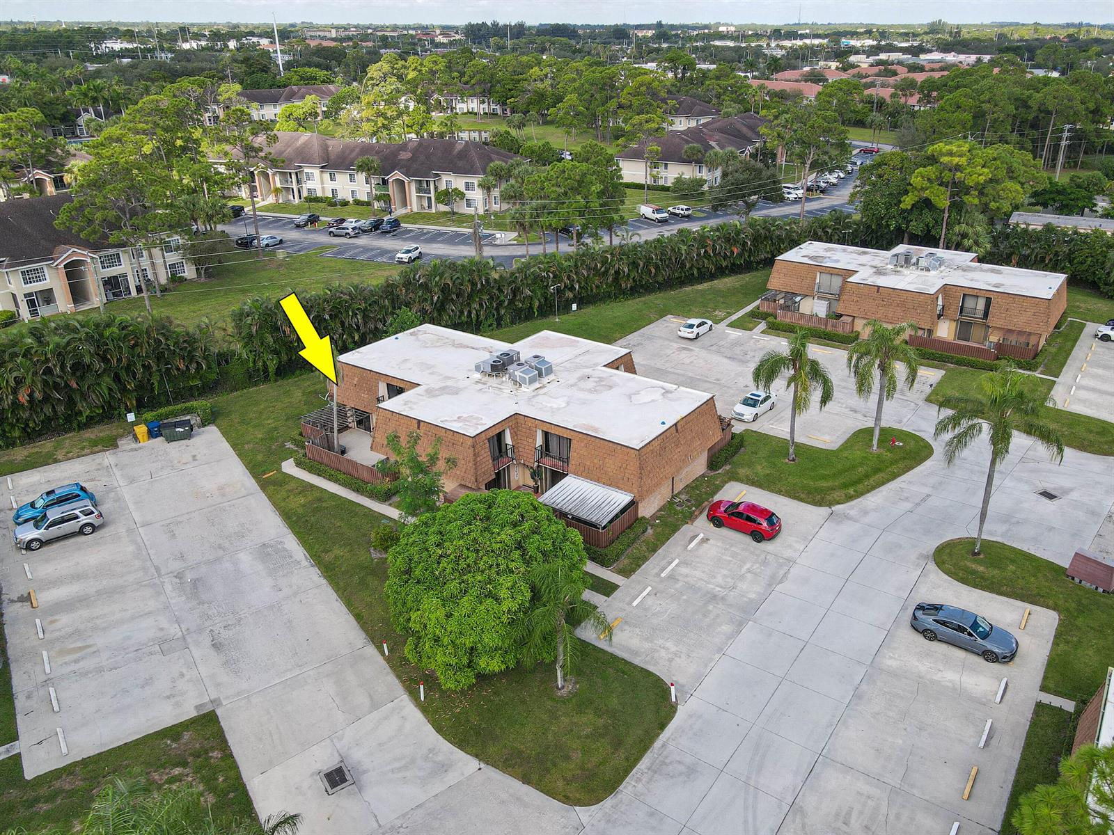 An aerial view shows a two-story brick apartment building with a flat roof and parking — 2406 24th Lane, FL 33463, FL
