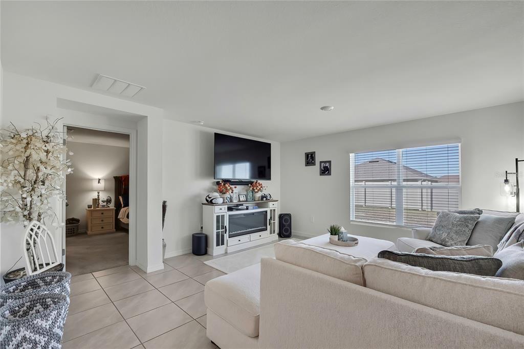 A living room features tile flooring, a white media console with a fireplace, and a sofa — 377 W FAIRWAYS VIEW DRIVE, BEVERLY HILLS, FL