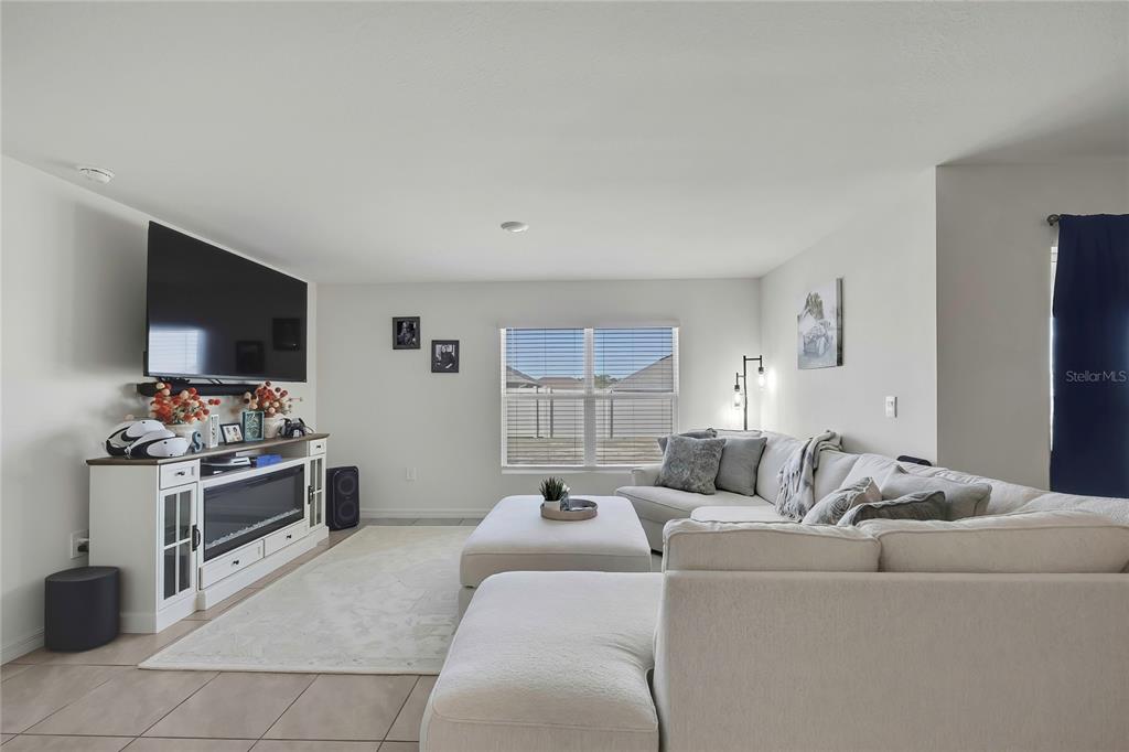 A living room features a white sectional sofa, a fireplace media console, and a window — 377 W FAIRWAYS VIEW DRIVE, BEVERLY HILLS, FL