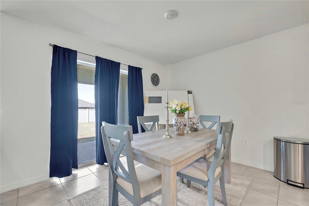A dining area features a light wood table, grey chairs, and a sliding glass door — 377 W FAIRWAYS VIEW DRIVE, BEVERLY HILLS, FL