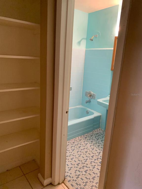 A view through a doorway shows a bathroom with a blue tub, tile, and flooring — 21266 COULTON AVENUE, PORT CHARLOTTE, FL