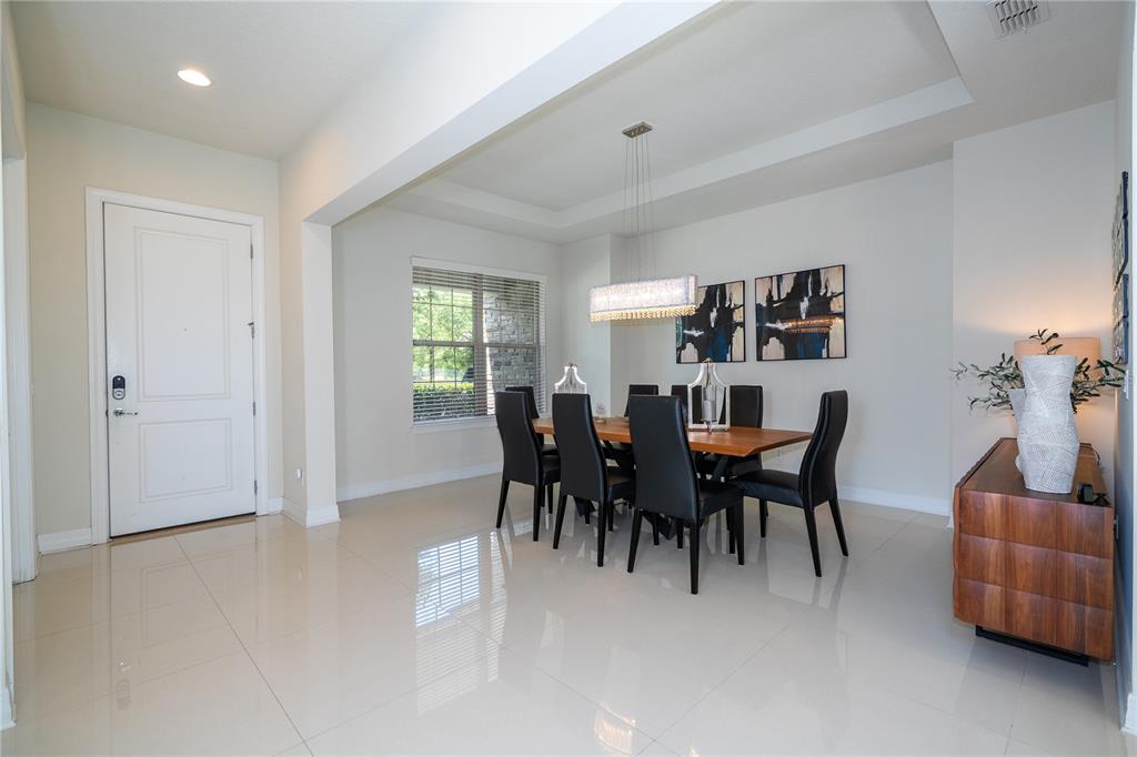 A dining room features a wooden table, black chairs, a chandelier, and tile flooring — 11142 LEMON LAKE BOULEVARD, ORLANDO, FL