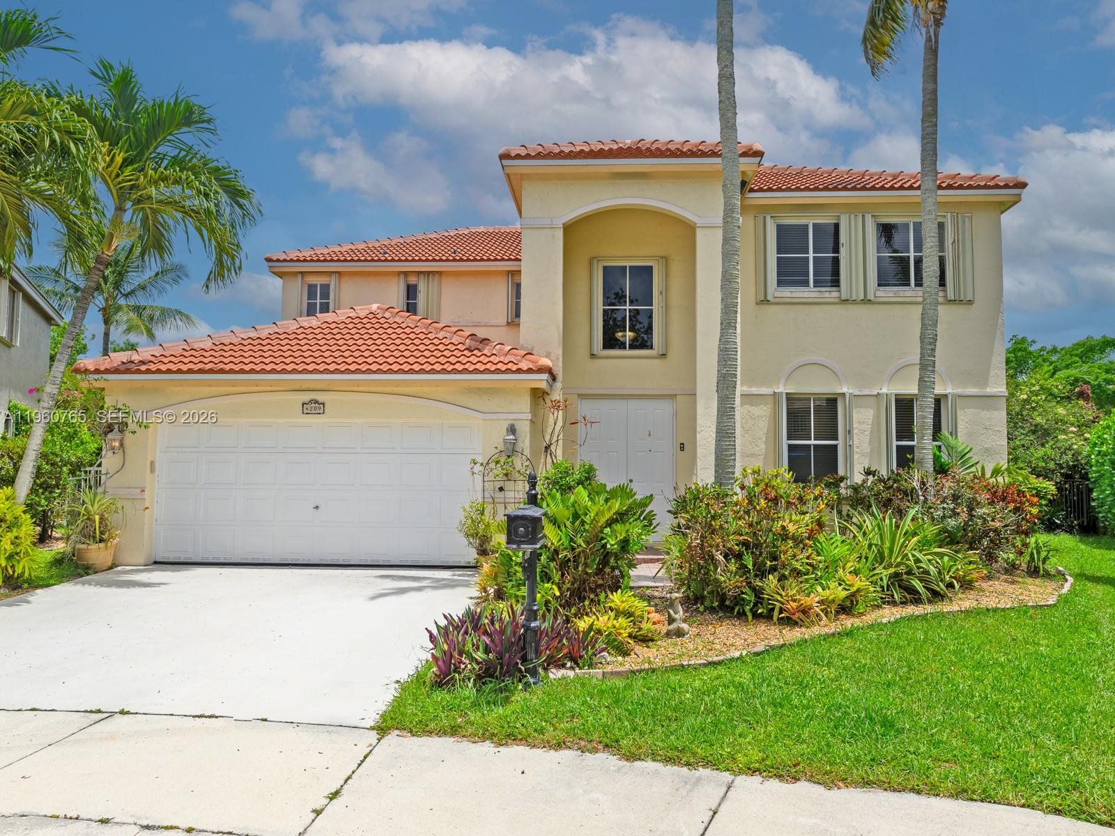A two-story stucco house with a tile roof and a two-car garage — 4209 Pinewood Ln, Weston FL 33331, WESTON, FL