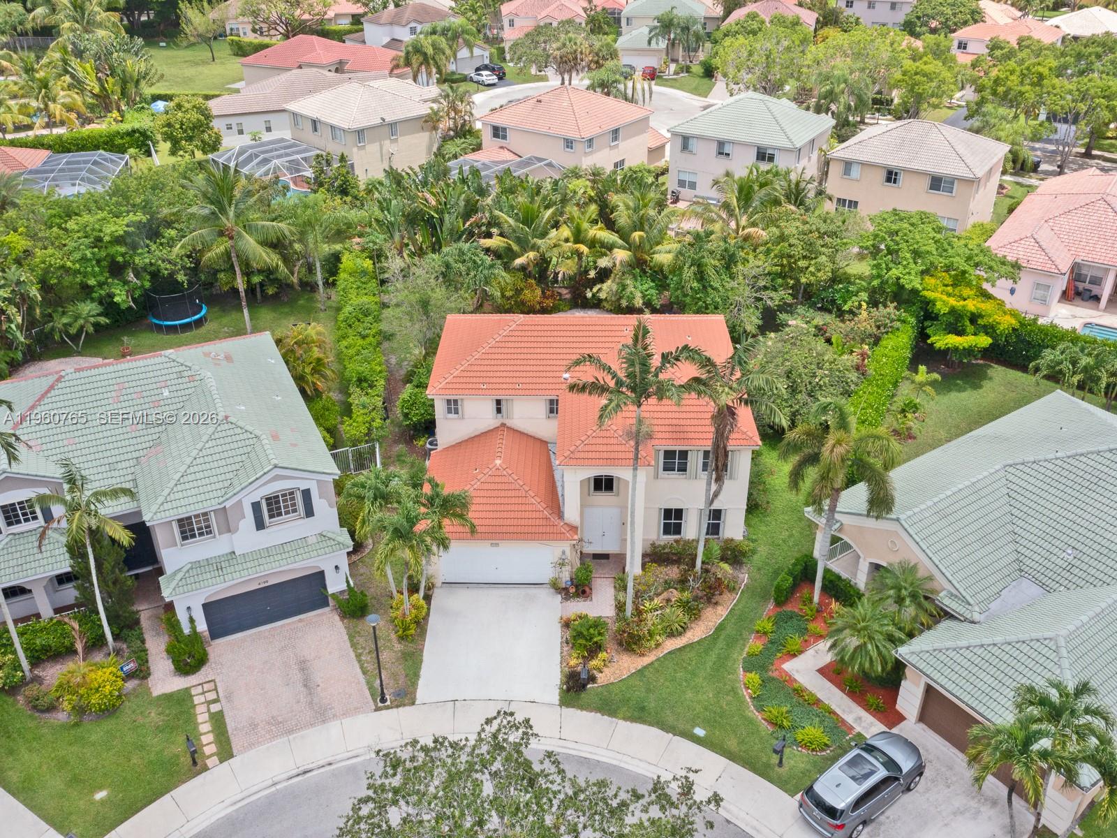 An aerial view shows a two-story house with a terracotta roof in a suburban neighborhood — 4209 Pinewood Ln, Weston FL 33331, WESTON, FL