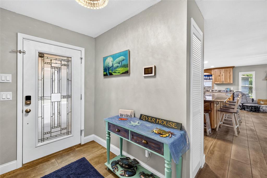 An entryway features a white front door, a blue console table, and wood-look tile flooring — 4600 S LEWOODS DRIVE, HOMOSASSA, FL