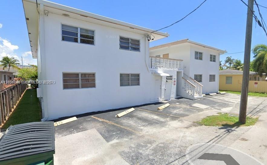 A two-story white apartment building features a paved parking lot with numbered spaces — 1610 Liberty St # 1, Hollywood FL 33020, HOLLYWOOD, FL