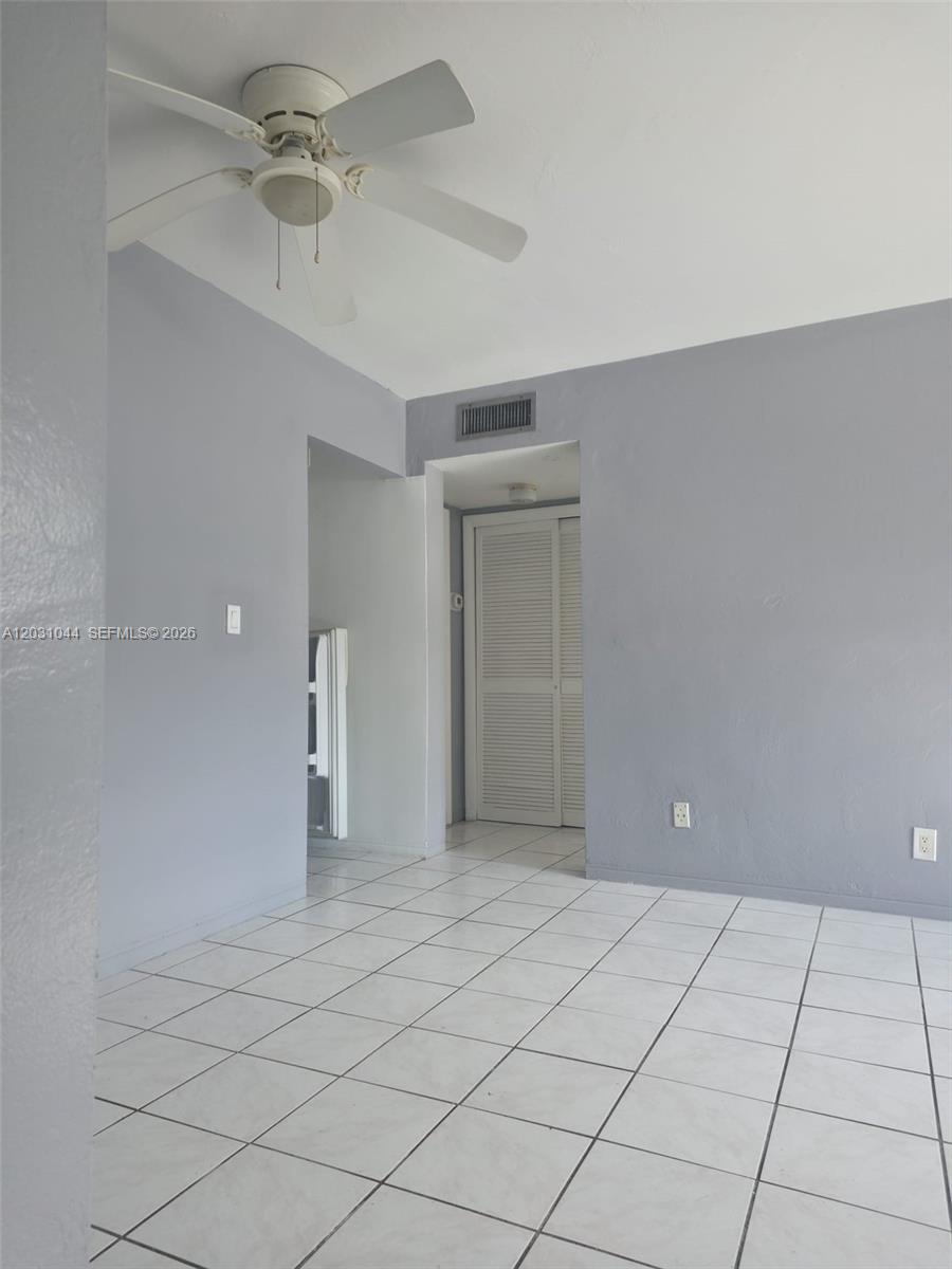 A room with gray walls, white tiled flooring, a ceiling fan, and a closet — 1610 Liberty St # 1, Hollywood FL 33020, HOLLYWOOD, FL