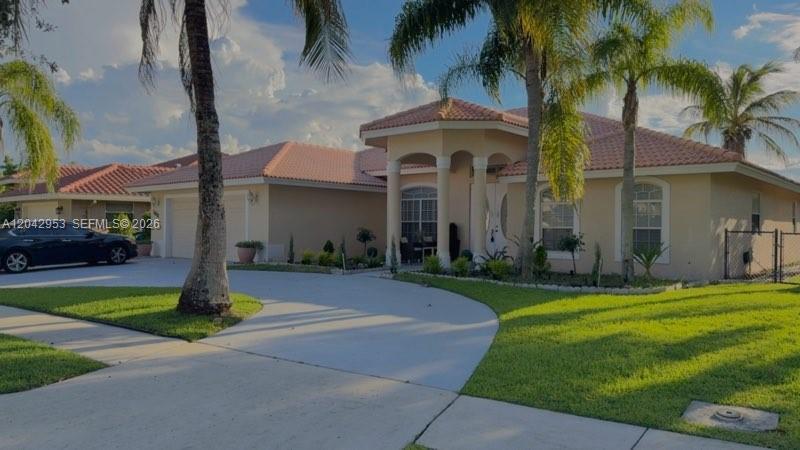 A single-story house with a tiled roof, arched entryway, and palm trees in the yard — 165 Cypress Trce, Royal Palm Beach FL 33411, ROYAL PALM BEACH, FL