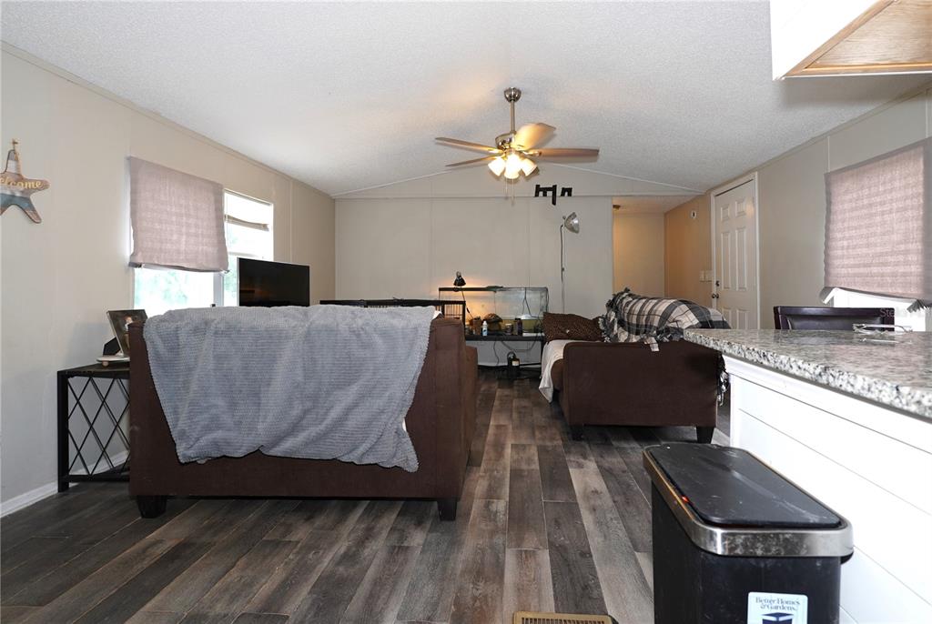 A living room features wood-look flooring, a ceiling fan, and two brown sofas — 14041 SE 90TH TERRACE, SUMMERFIELD, FL