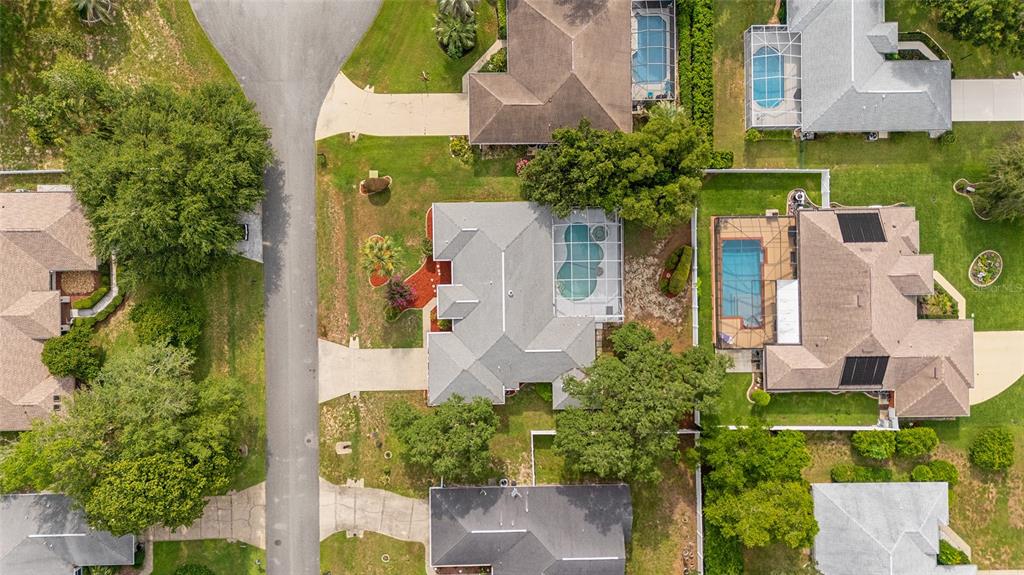 An aerial view shows several suburban houses with swimming pools and surrounding trees and lawns — 5366 SW 86TH PLACE, OCALA, FL