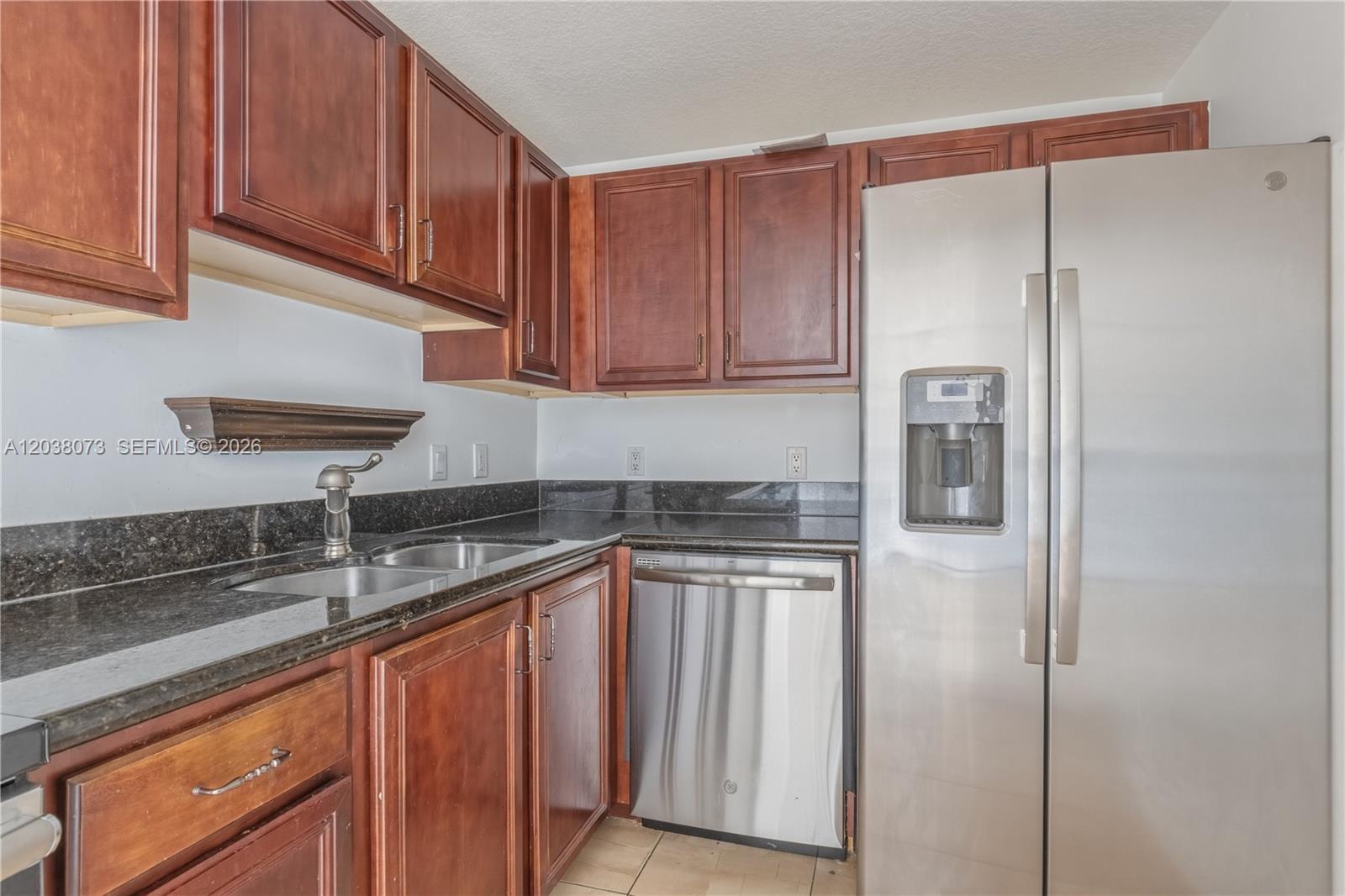 A kitchen features dark wood cabinets, granite countertops, and stainless steel appliances — 5271 SW 8th St # 304, Miami FL 33134, MIAMI, FL