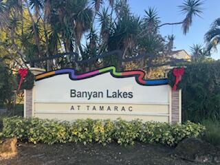 A sign for Banyan Lakes at Tamarac stands in front of palm trees and landscaping — 6194 Pine Tree Lane # D, Tamarac FL 33319, TAMARAC, FL