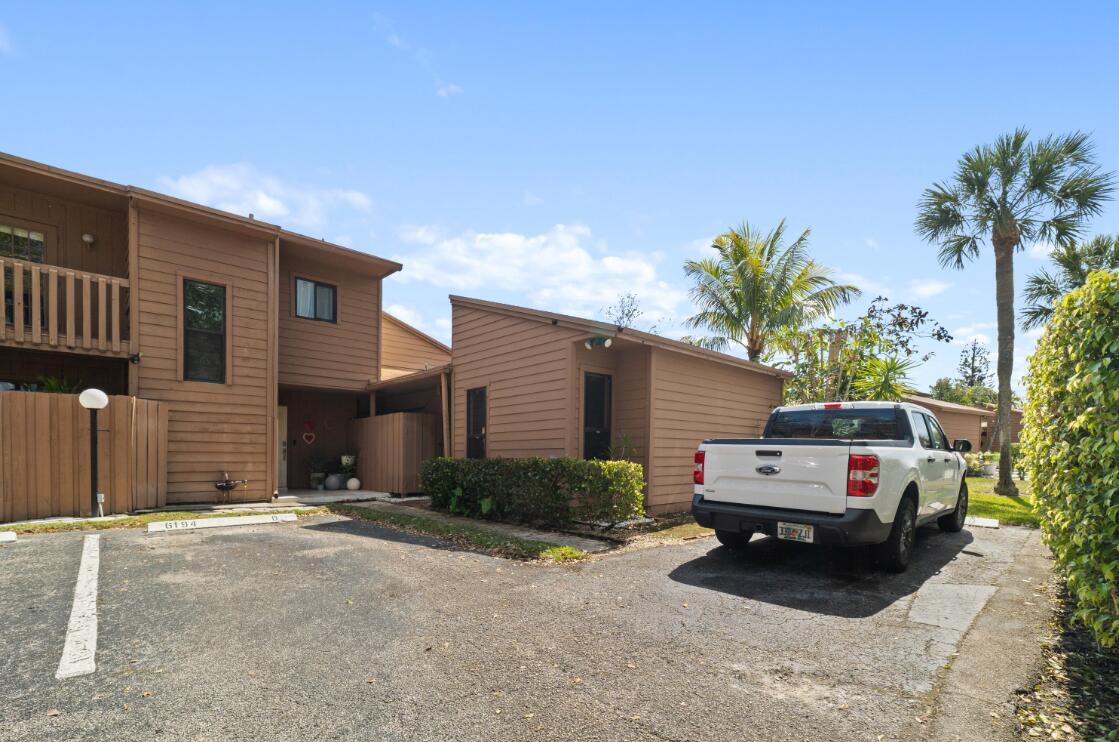 A two-story brown wood-sided townhouse with a white pickup truck parked in the driveway — 6194 Pine Tree Lane # D, Tamarac FL 33319, TAMARAC, FL