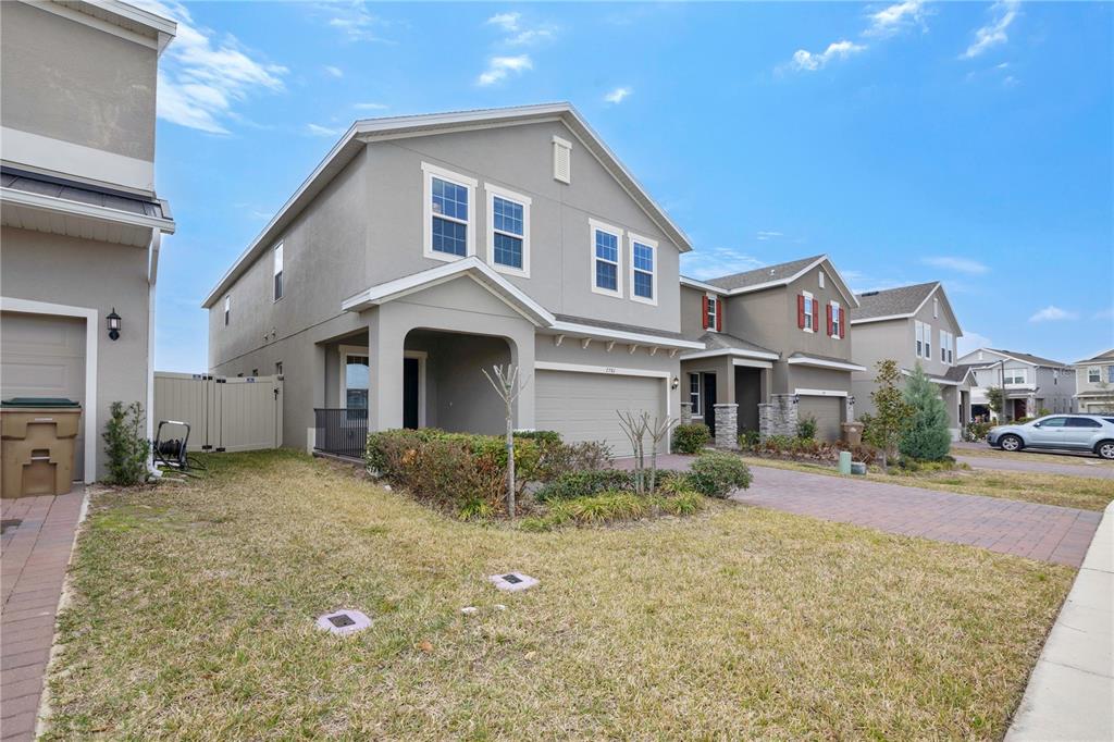 A two-story suburban house with a gray stucco exterior and an attached two-car garage — 7781 MARSALA STREET, CLERMONT, FL