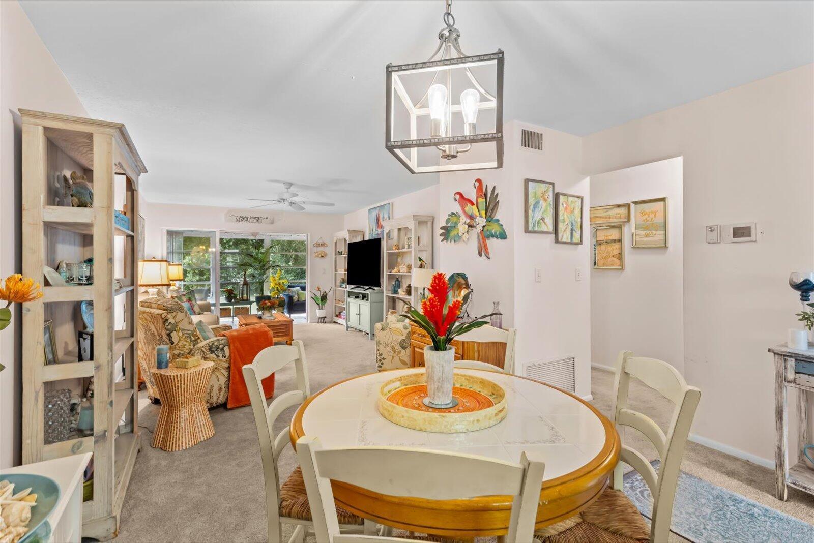 A dining area with a round table sits in the foreground of a living room — 2929 SE Ocean Boulevard # 130, Stuart FL 34996, STUART, FL