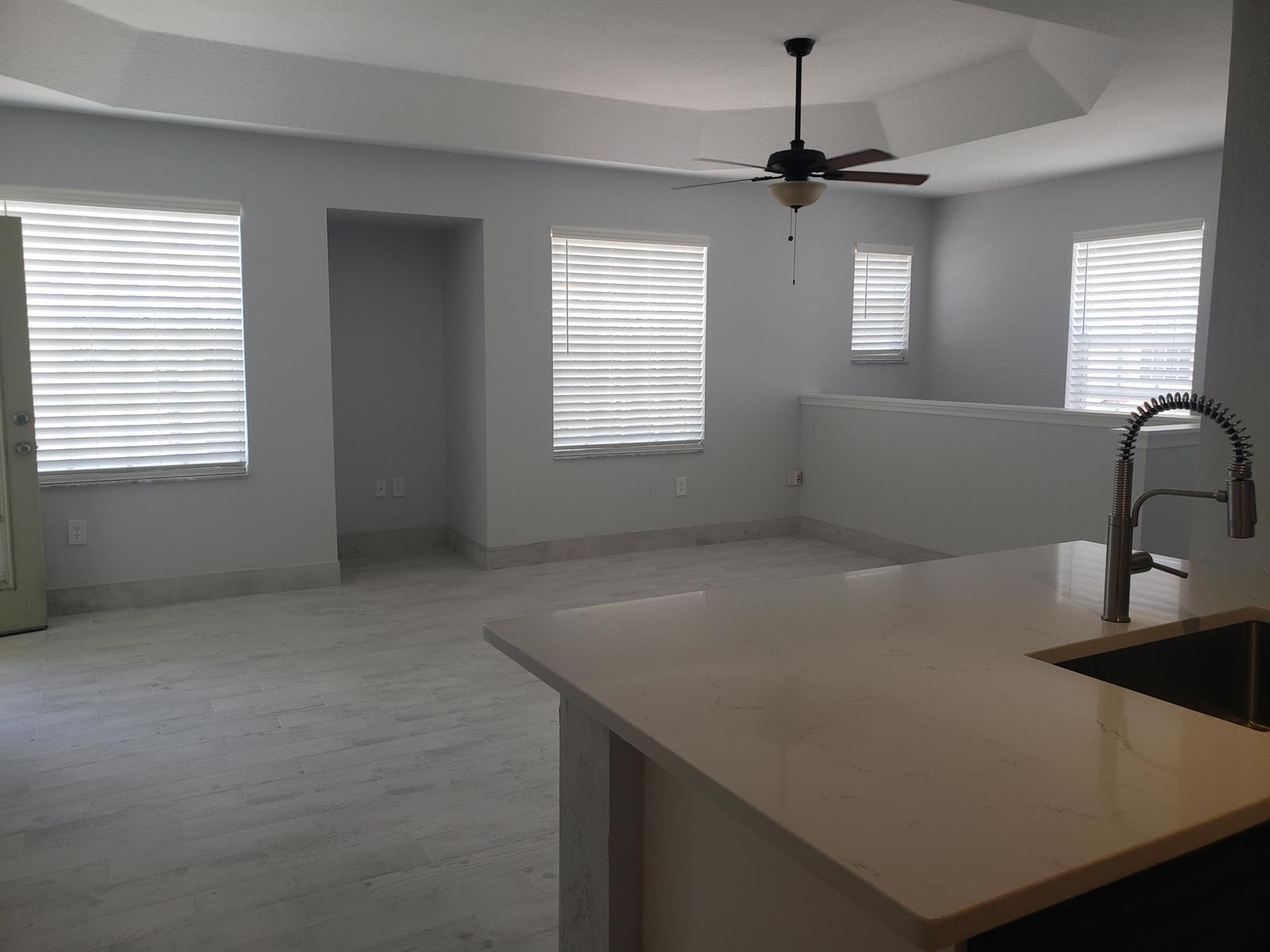 An open-concept room with light gray walls, white tile flooring, and a kitchen island — 1005 Belmont Place # 1005, Boynton Beach FL 33436, BOYNTON BEACH, FL