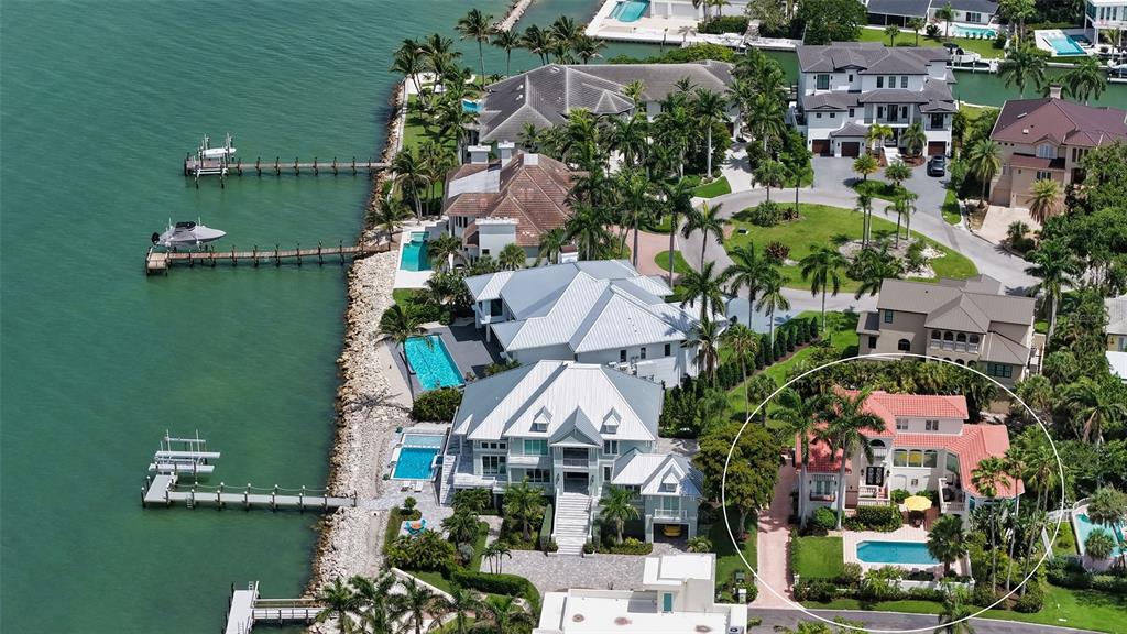 An aerial view shows several waterfront luxury homes with pools and private docks — 1023 TOCOBAGA LANE, SARASOTA, FL