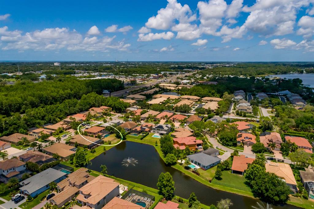 An aerial view shows a residential neighborhood with a lake and a circled house — 4611 GRAND PRESERVE PLACE, PALM HARBOR, FL